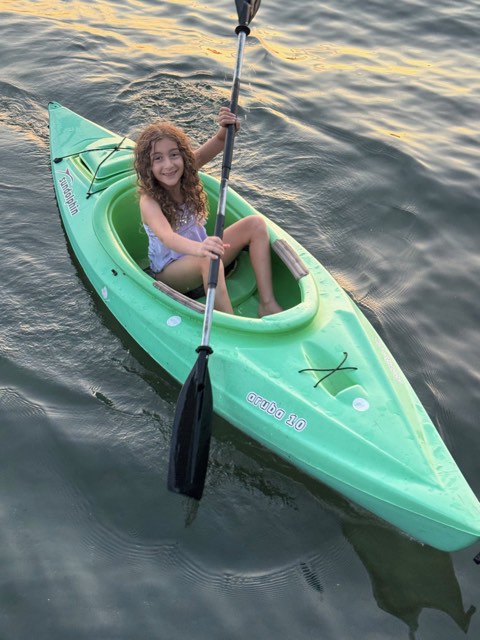 Eve paddling a kayak on the water
