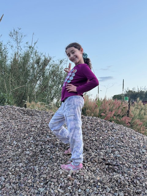 Eve striking a pose on top of a big pile of gravel at dusk