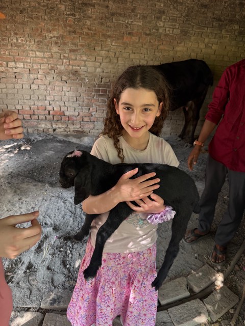Eve holding a small black baby goat in her arms